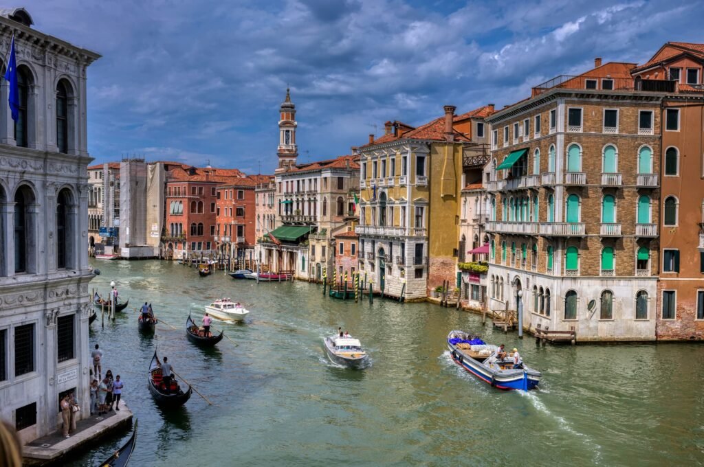 rialto bridge crossing the grand canal in venice along with boats on the river